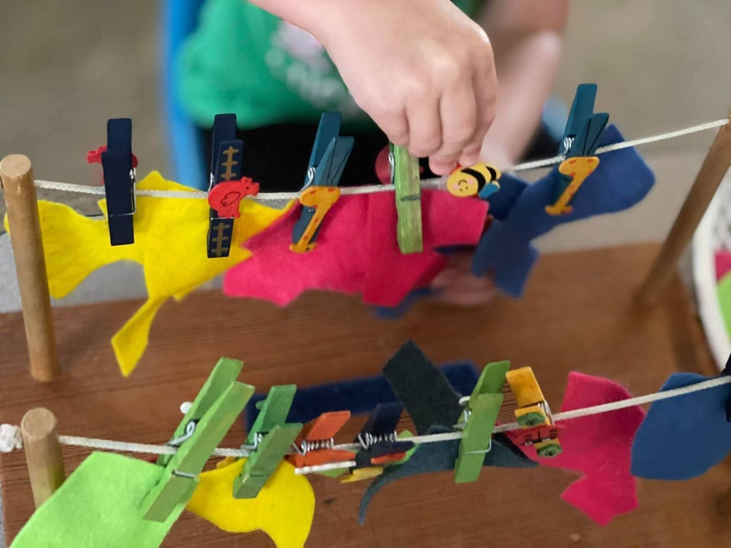 Child's hand clips a clothespin