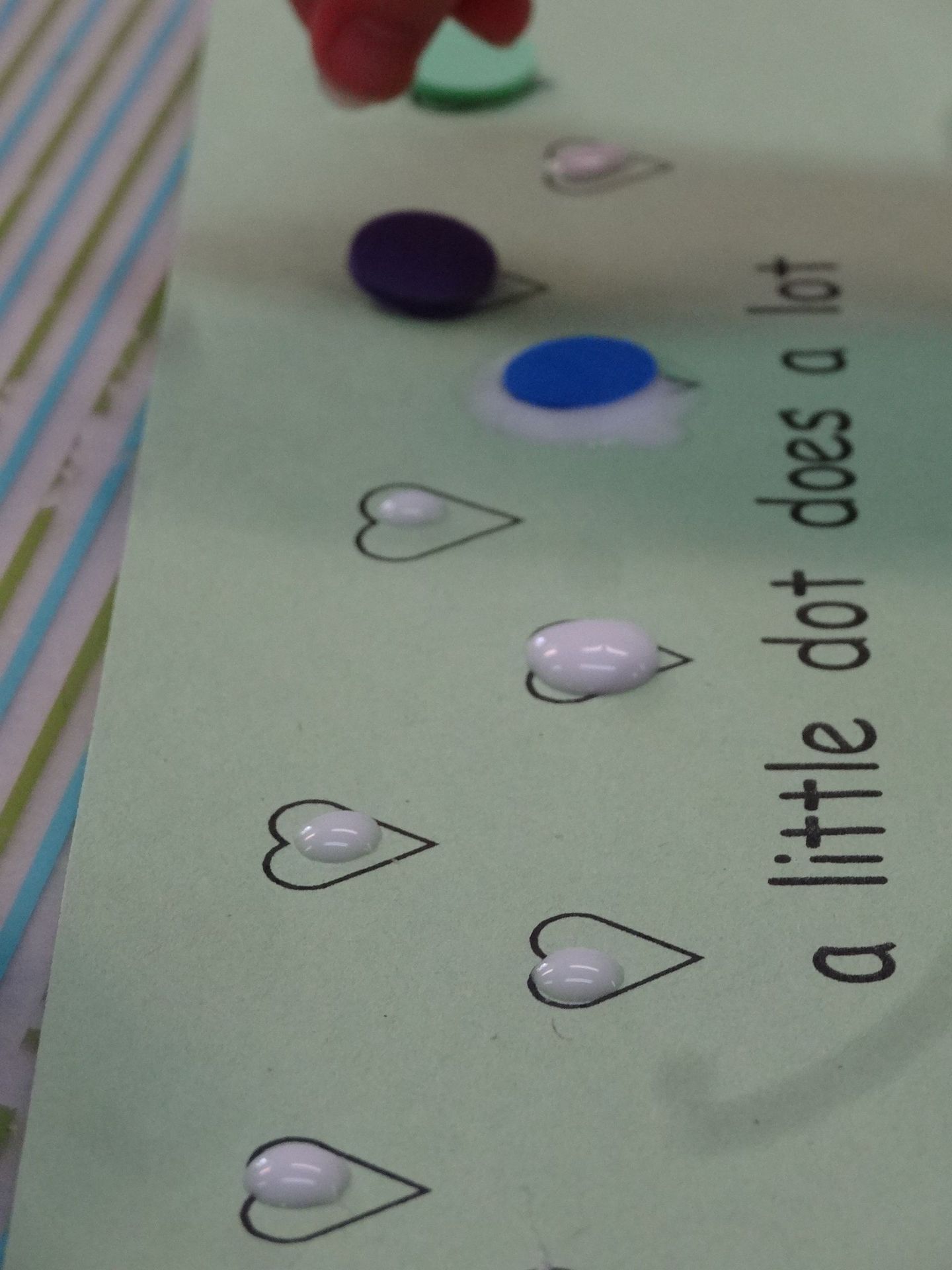Green paper with painted white hearts and colored dots