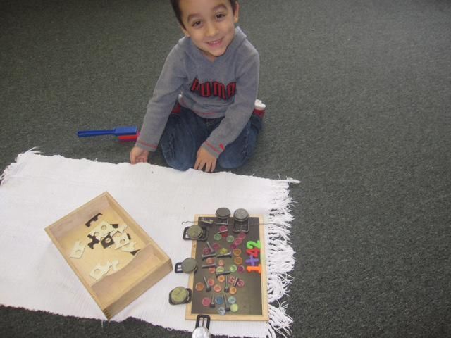 Young boy kneeling near a board game with colorful pieces