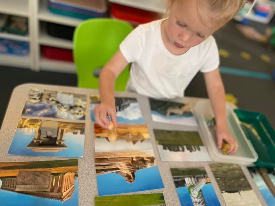 Young child sorting picture cards at a table