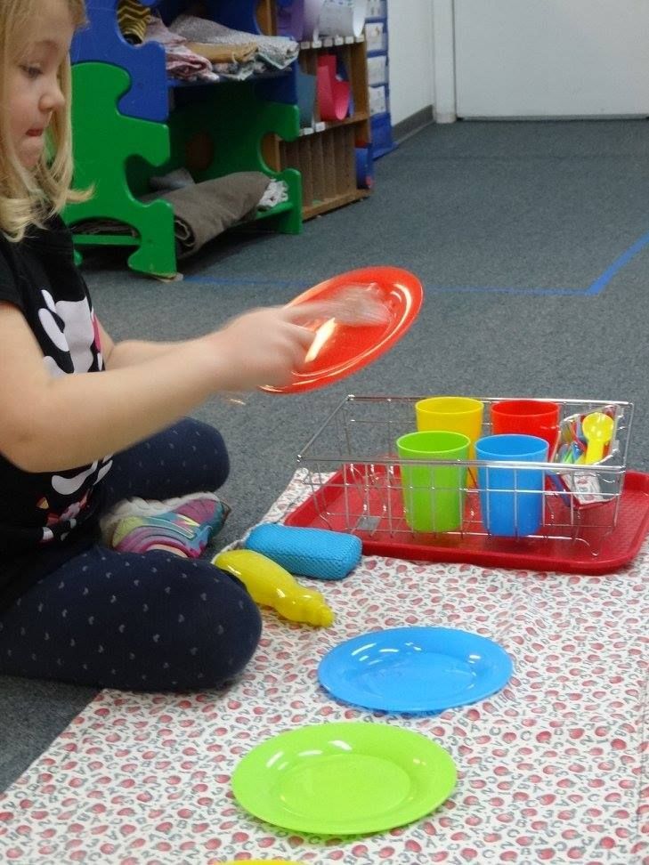 A child playing with toy dishes