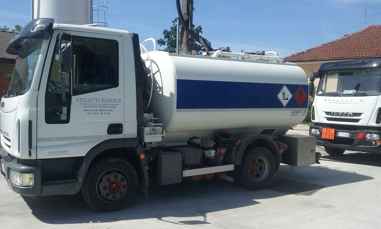 Un'autocisterna bianca è parcheggiata accanto a un altro camion