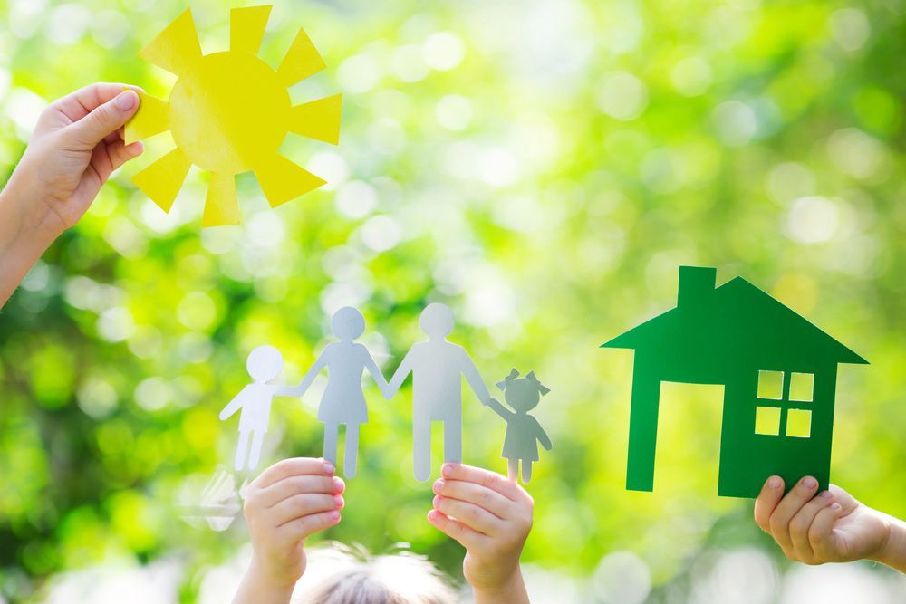 A Group of People Are Holding Paper Cut Outs of A Family, Sun, and House - Healthy Cleaning Solutions in Scotts Head, NSW