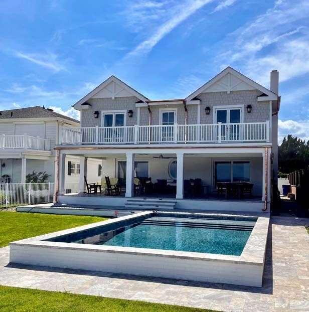 A large house with a large swimming pool in front of it