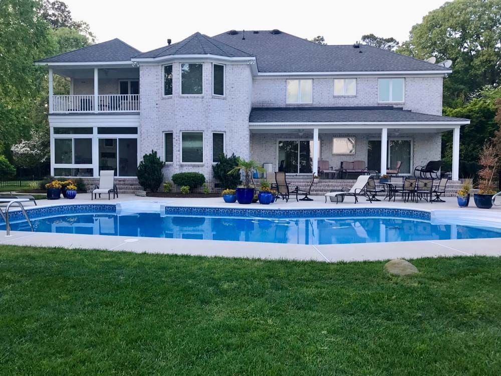 A large white house with a large swimming pool in front of it