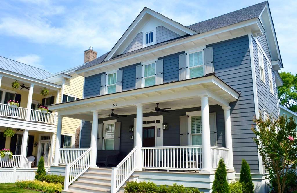 A large house with a large porch and stairs leading up to it.