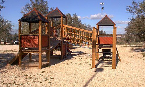 Un parco giochi con scivoli e casette in legno 