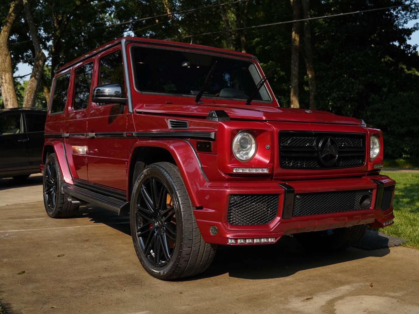 A white bmw i8 is parked in a grassy field at a car show.