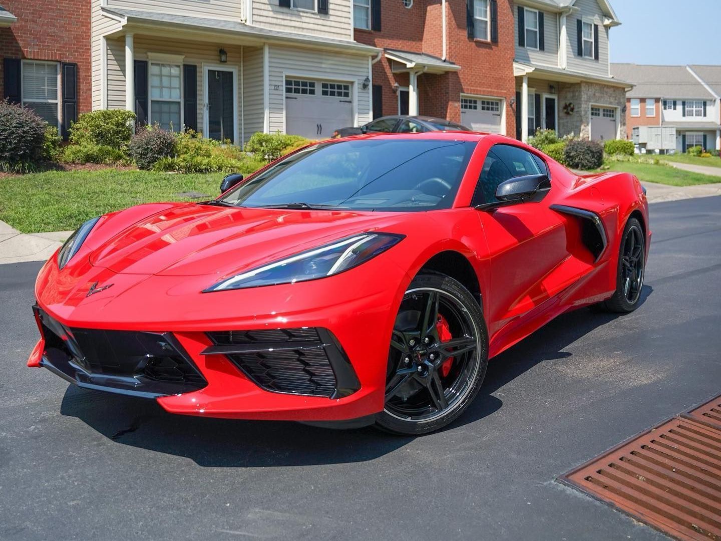 A yellow sports car is parked in front of a wooden building.