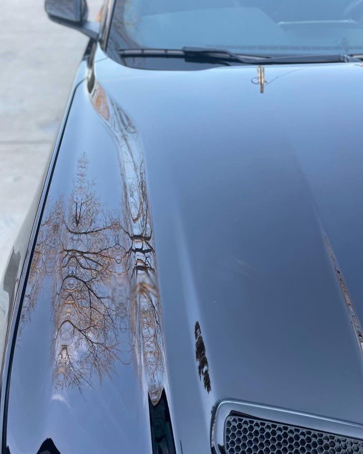 A close up of the hood of a black car.