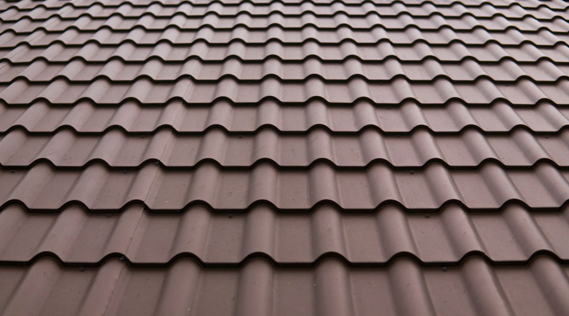 Brown metal roof tiles in a repeating wave pattern.