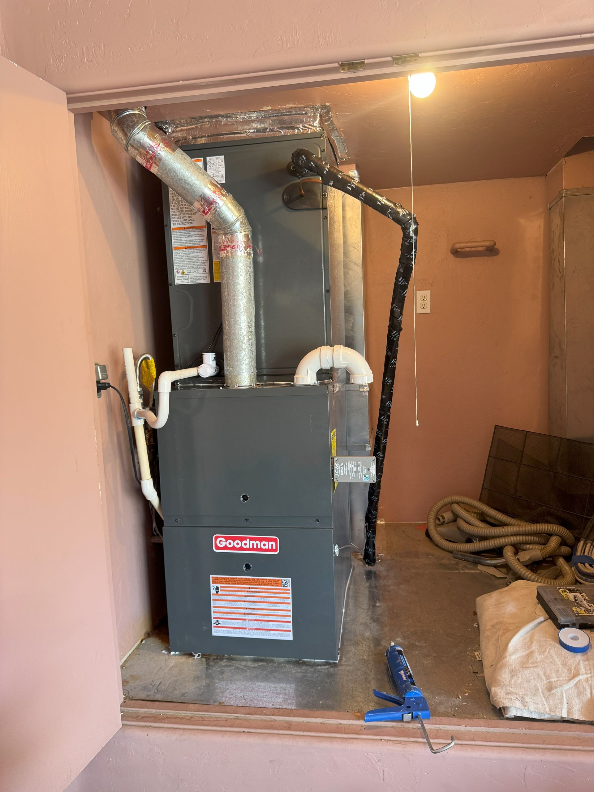 A furnace is sitting in a room next to a window.