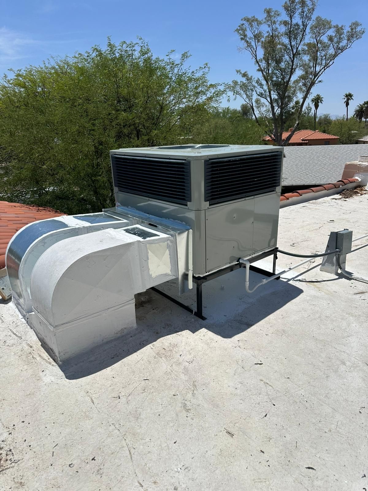 A large air conditioner is sitting on top of a roof.