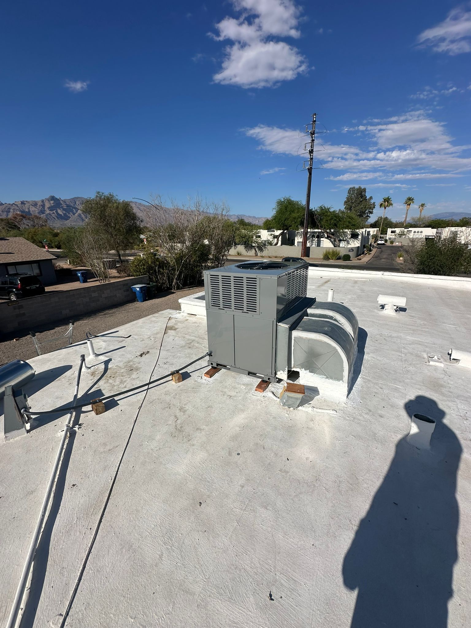 There is a shadow of a person on the roof of a building.