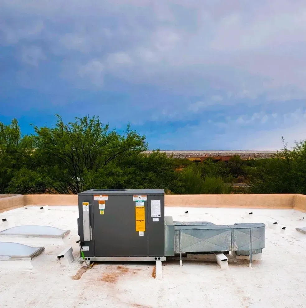 A black box with a yellow sticker on it is sitting on top of a white roof.