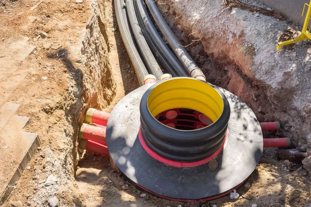 A Yellow-rimmed Plastic Inspection Chamber Set in a Dirt Trench — Copp & Co Civil Plant Hire in Airlie Beach, QLD