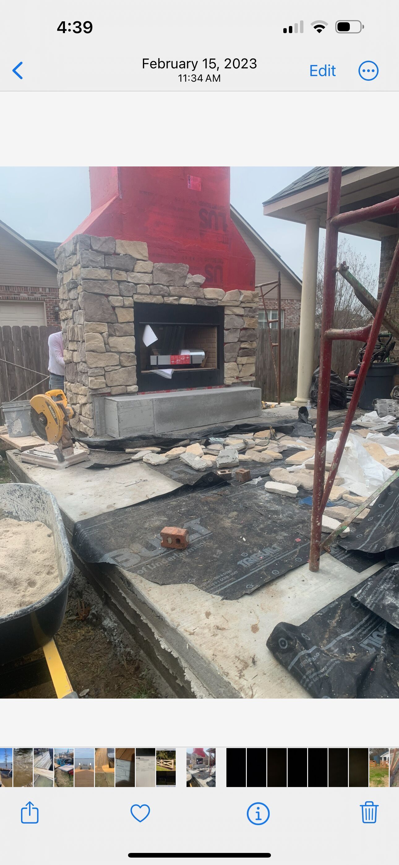 A picture of a fireplace being built on the side of a house.