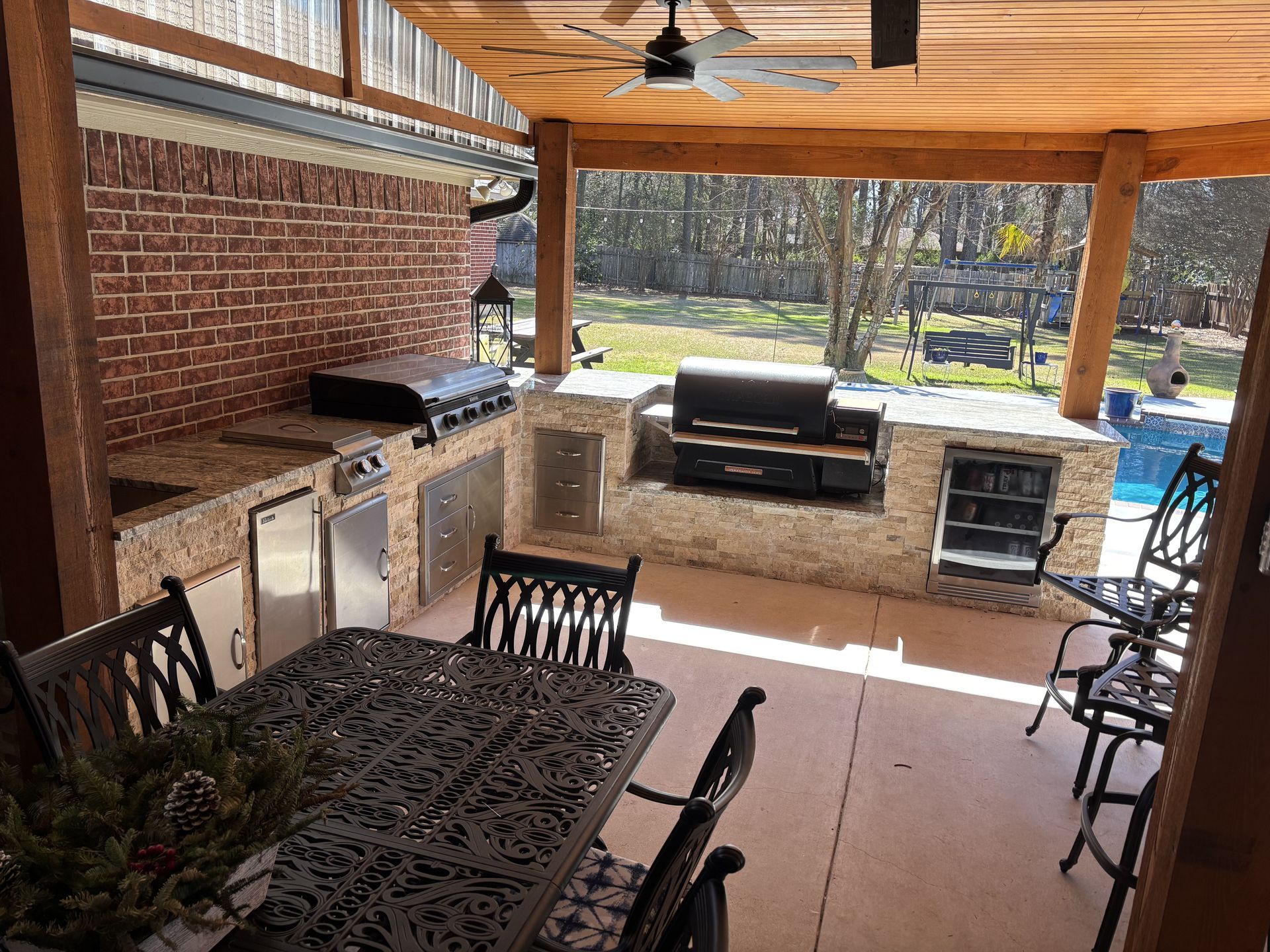 A patio with a table and chairs and a grill.