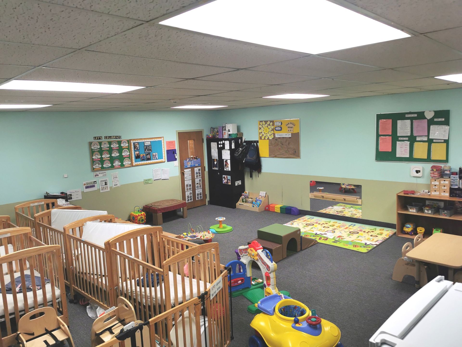 carpeted daycare room with book shelf and round tables