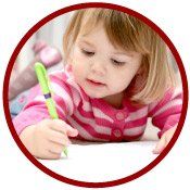 portrait of little girl writing with green crayon