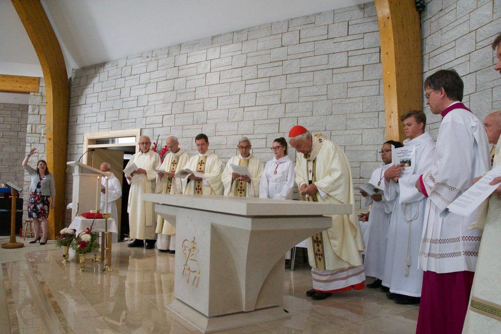 a group of priests are standing around an altar in a church .