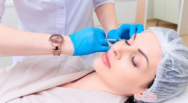 A woman is getting a botox injection in her face.