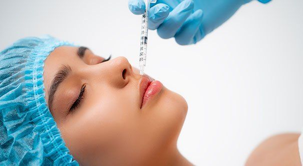 A woman is getting a botox injection in her nose.