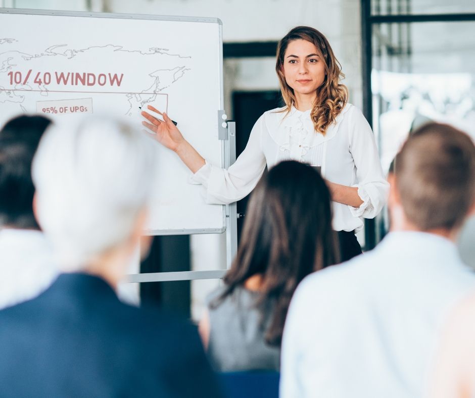 A woman is giving a presentation to a group of people.