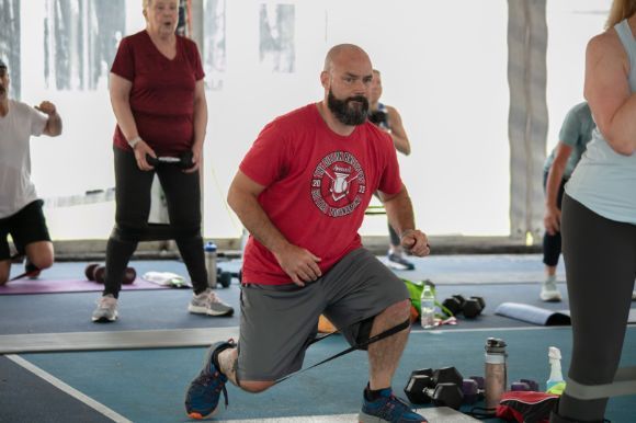 A group of people are doing exercises in a gym.