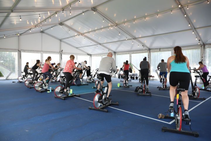 A group of people are riding exercise bikes in a gym.