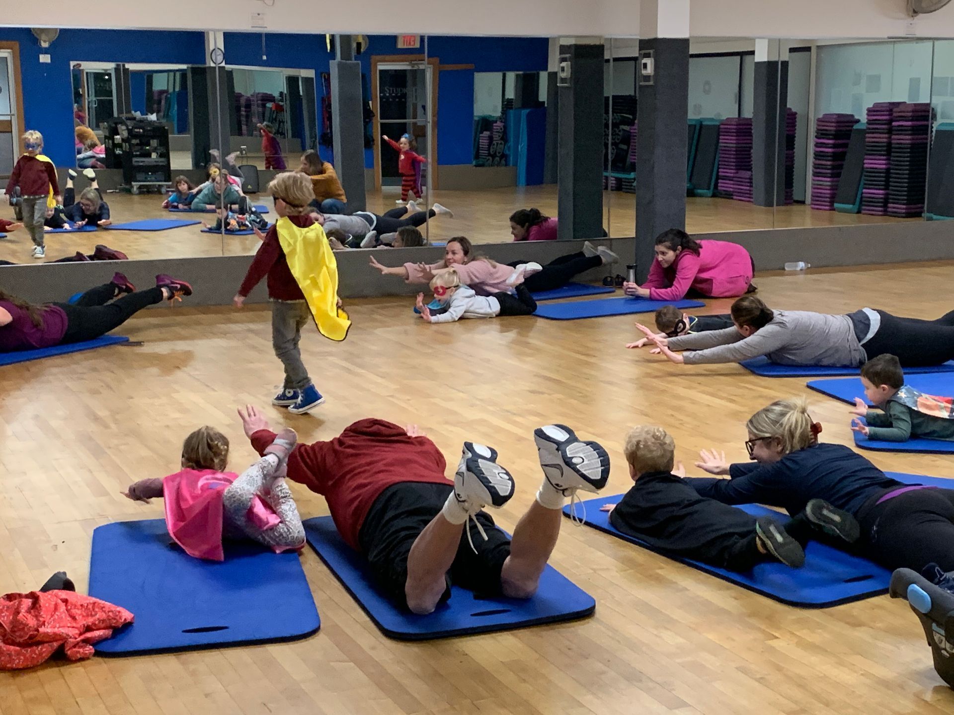 A group of people are doing exercises in a gym.