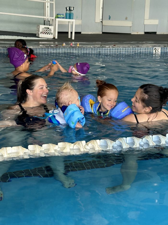 A group of people are swimming in a swimming pool.