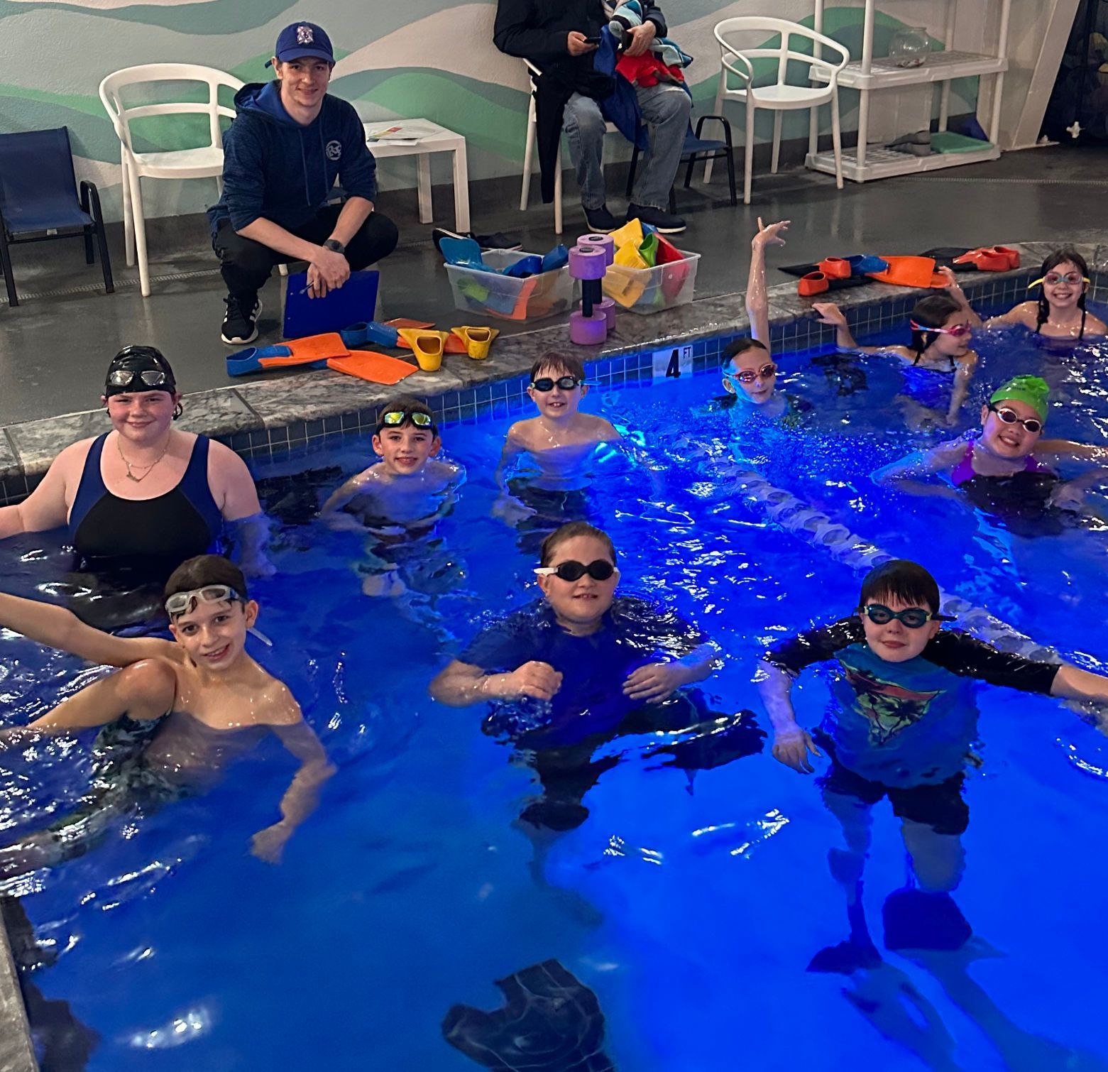 a group of people are swimming in a pool .