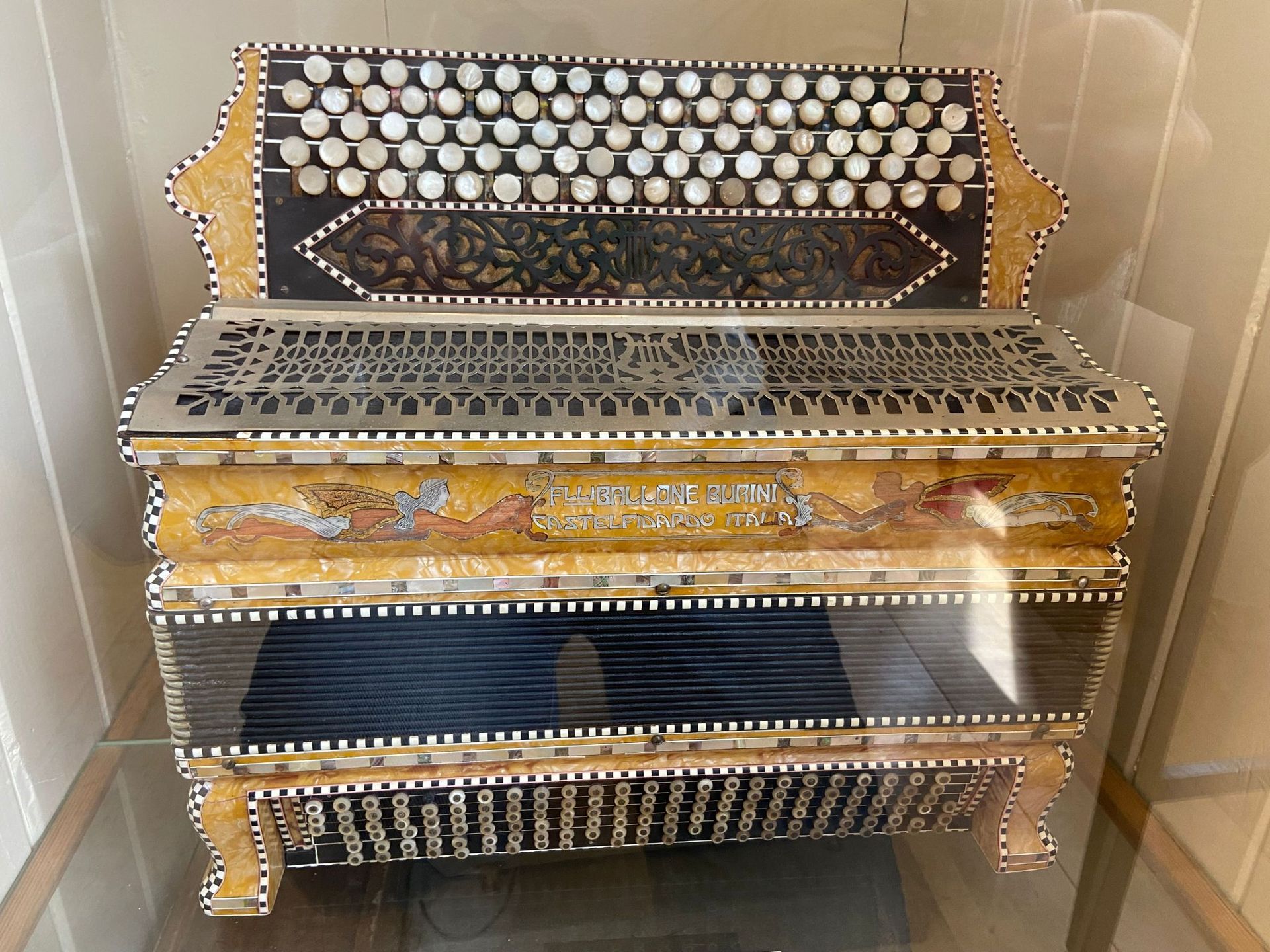 Een oude accordeon wordt tentoongesteld in een glazen kast