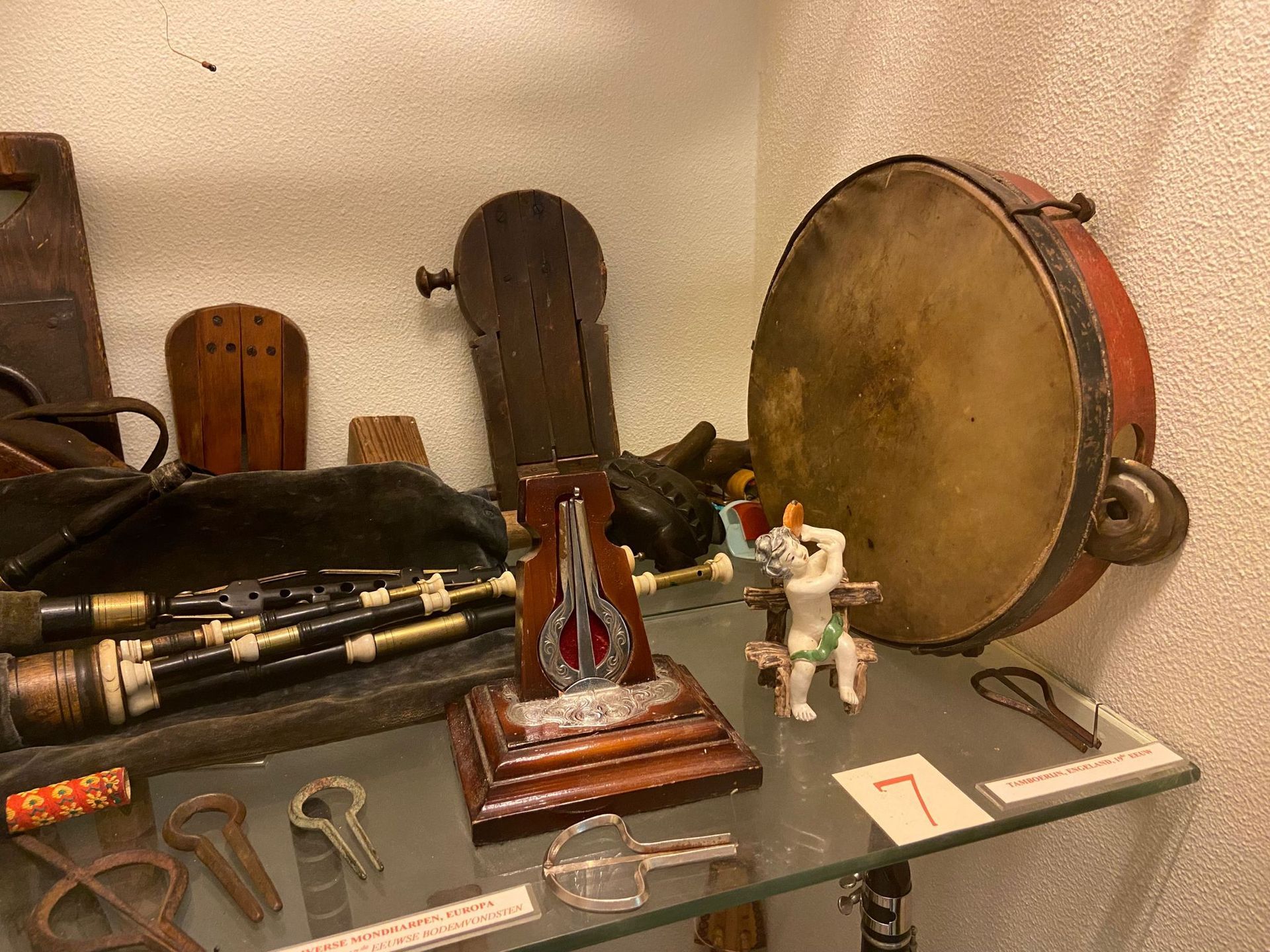 Een plank gevuld met diverse muziekinstrumenten waaronder een tamboerijn.