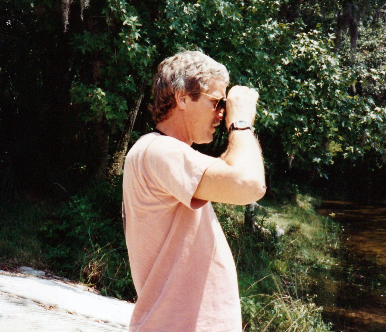 Image of Jim with binoculars next to forest