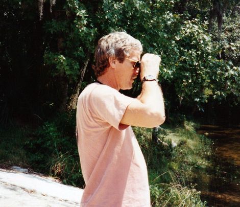 Image of Jim with binoculars next to forest