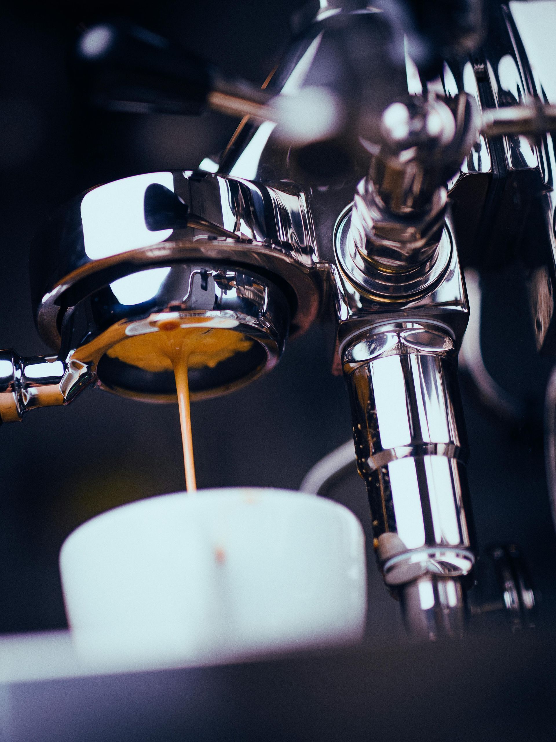 Espresso machine pouring coffee into a white cup, close-up view