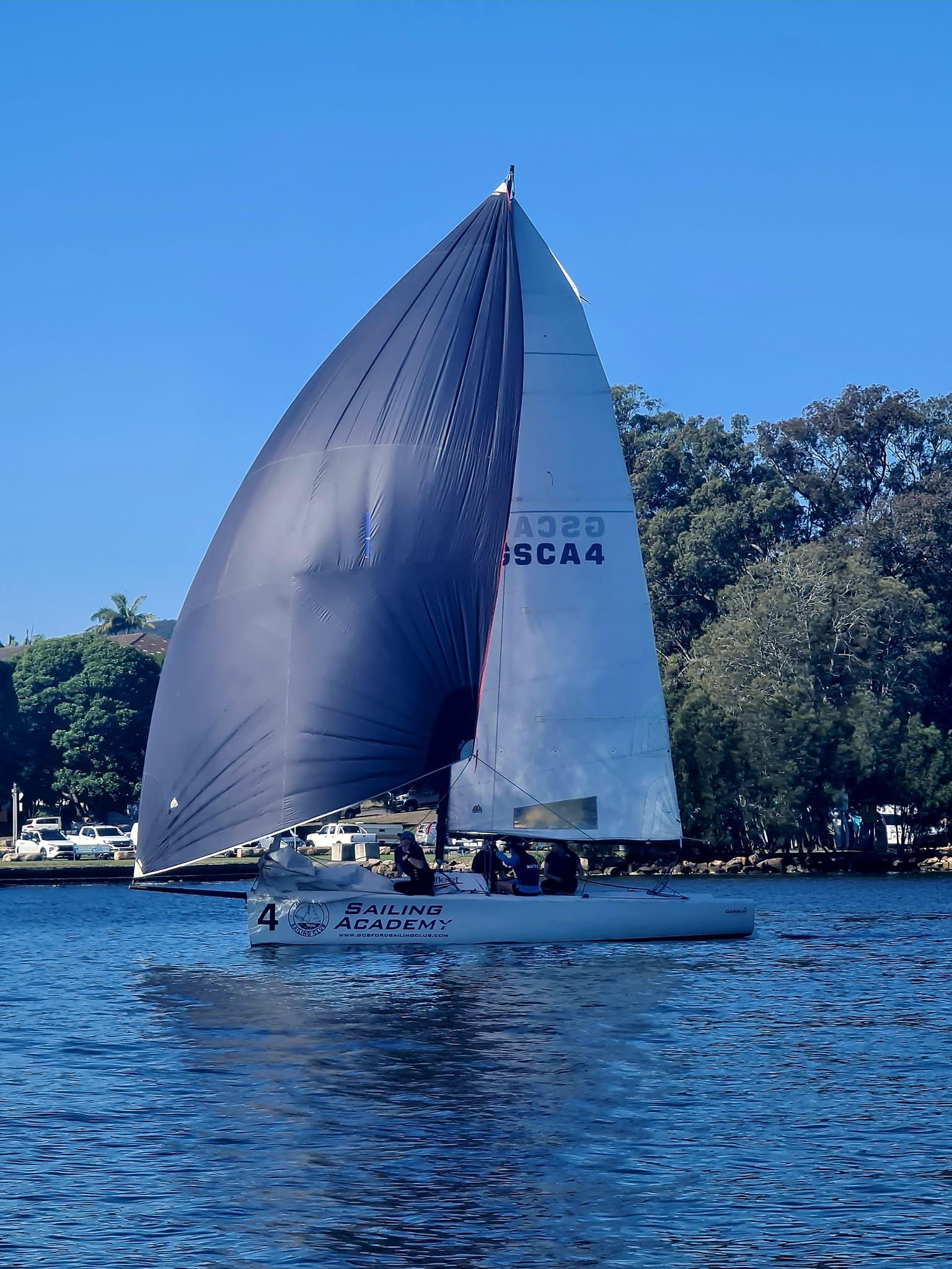 Sailboat With a Dark Blue Sail on Blue Water — Gosford Sailing Club in Gosford, NSW