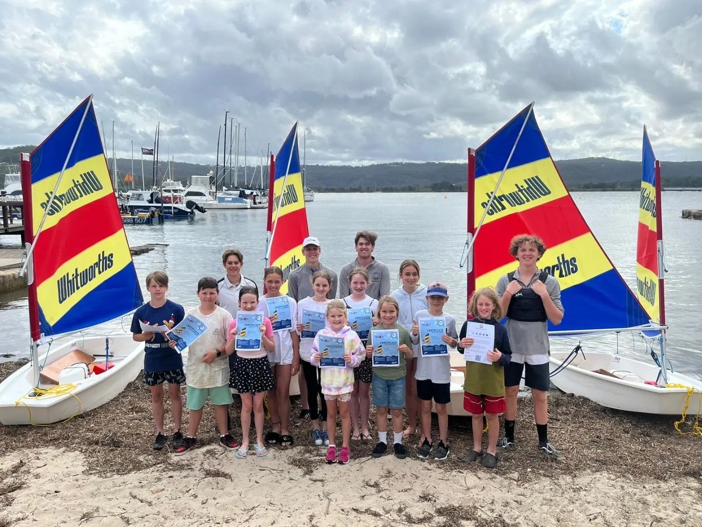Children With Certificates Stand Near Sailboats at a Marina — Gosford Sailing Club in Gosford, NSW