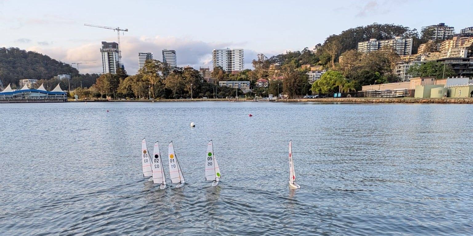 Sailboats on water with buildings and hills in the background. — Gosford Sailing Club in Gosford, NSW