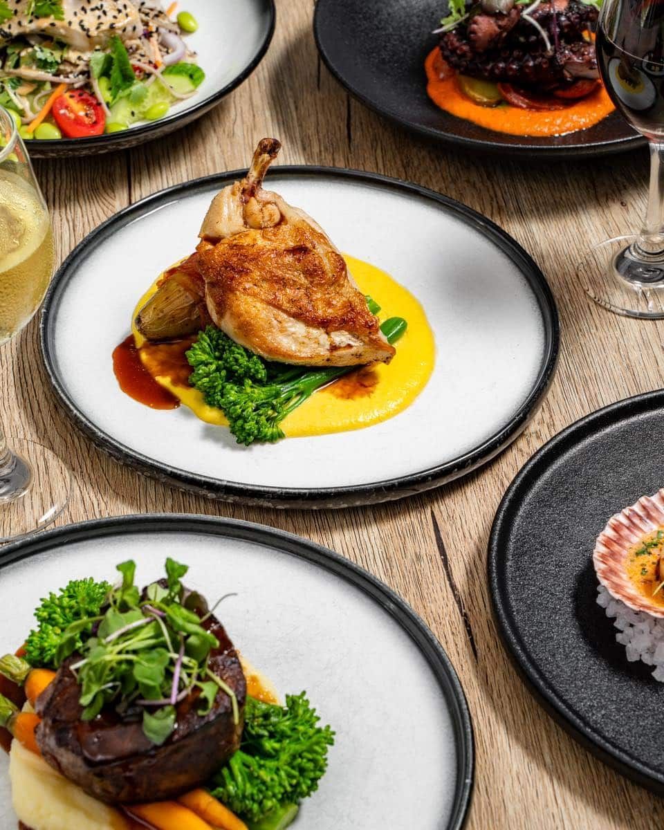 A Table Topped With Plates of Food and Wine Glasses — Gosford Sailing Club in Gosford, NSW