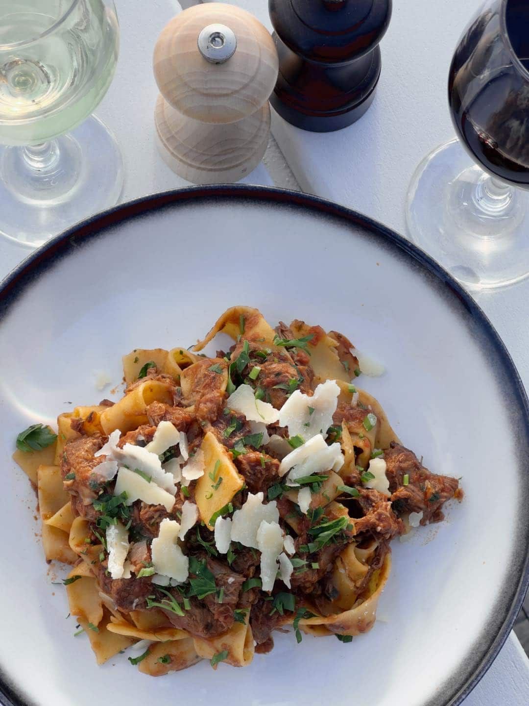 A Plate of Pasta With Meat and Cheese Next to a Glass of Wine — Gosford Sailing Club in Gosford, NSW