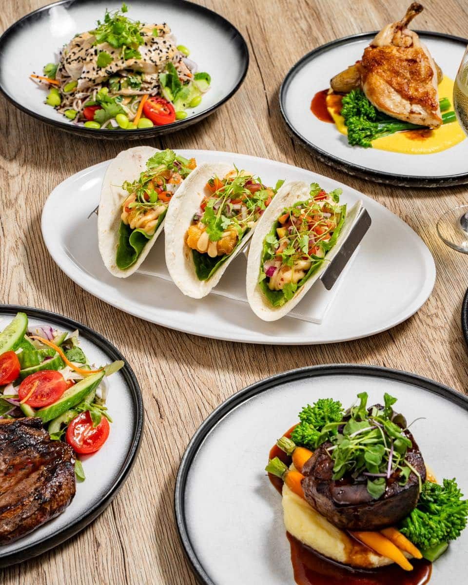 A Table Topped With Plates of Food Including Tacos and Steaks — Gosford Sailing Club in Gosford, NSW