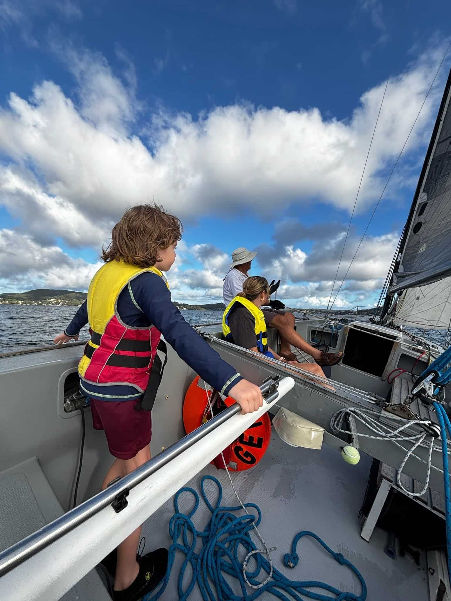 A Young Boy is Standing on the Deck of a Sailboat — Gosford Sailing Club in Gosford, NSW