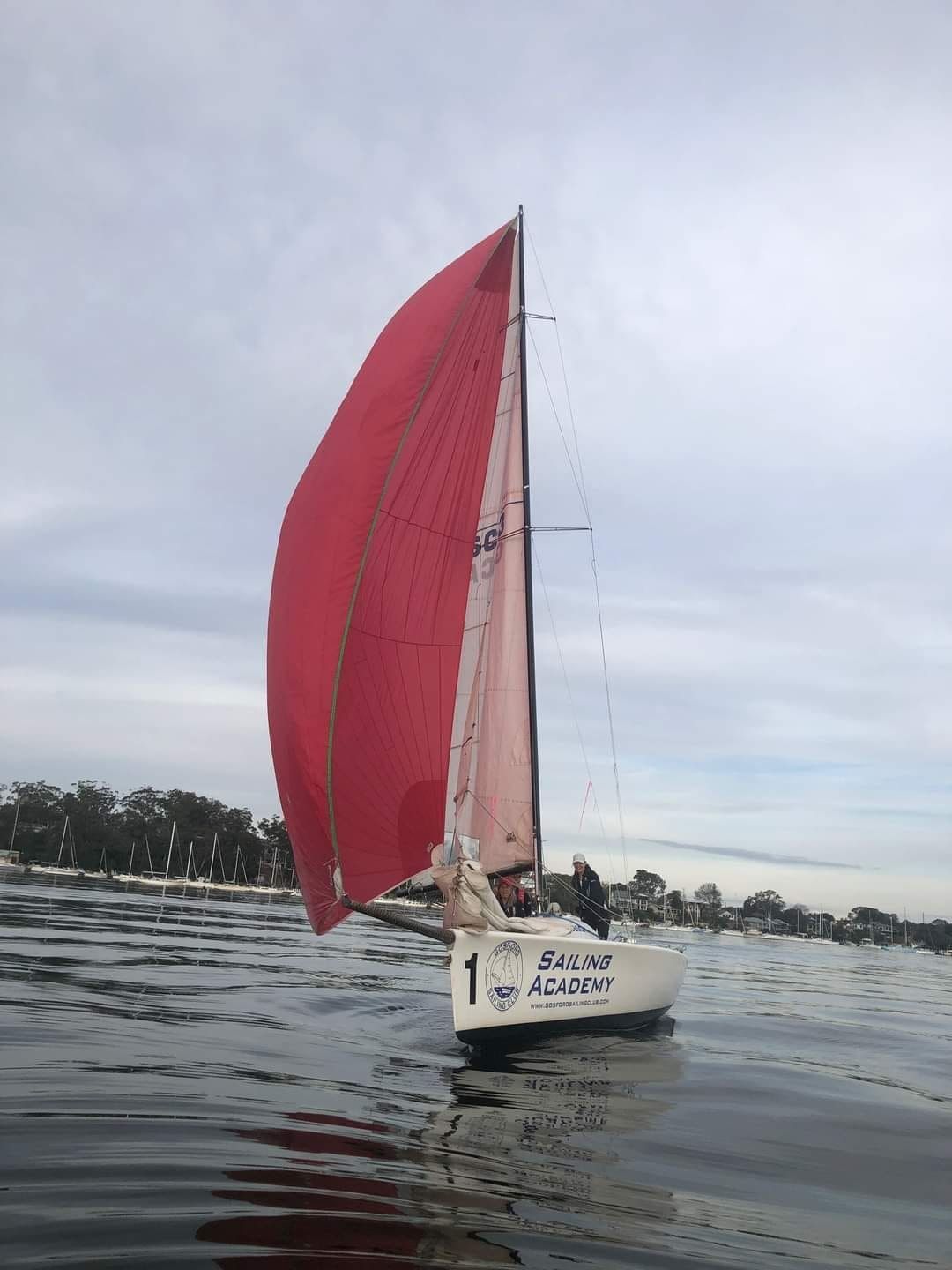 A Sailboat With a Red Sail is Floating on the Water — Gosford Sailing Club in Gosford, NSW