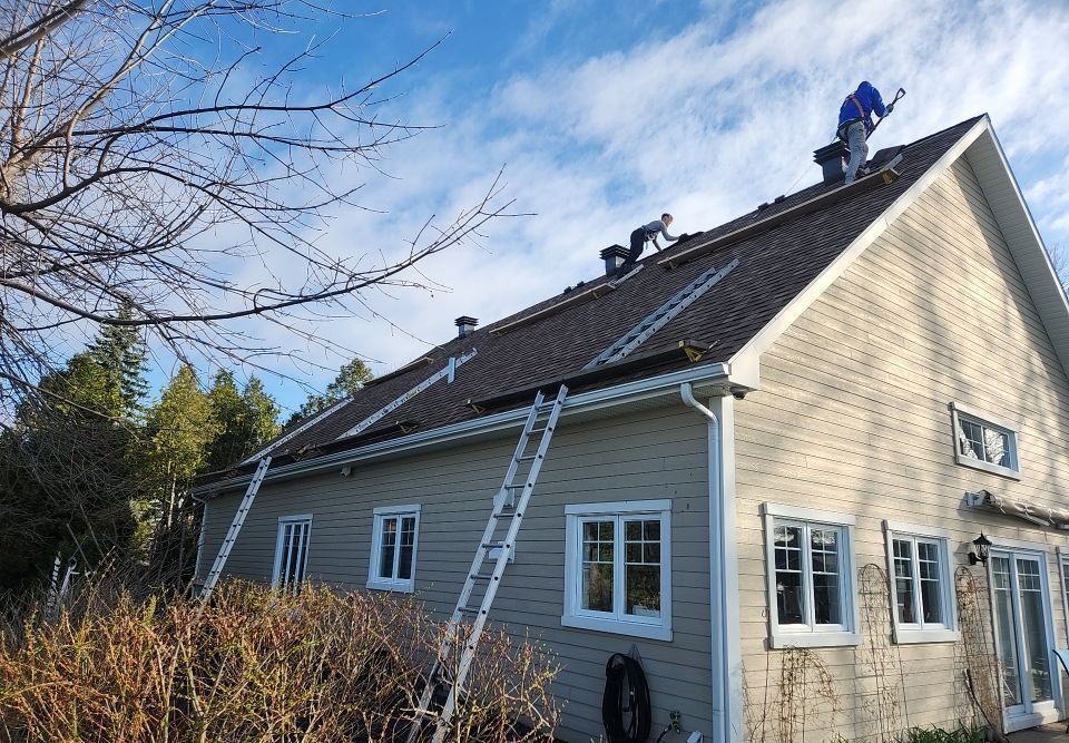 Un homme travaille sur le toit d'une maison.