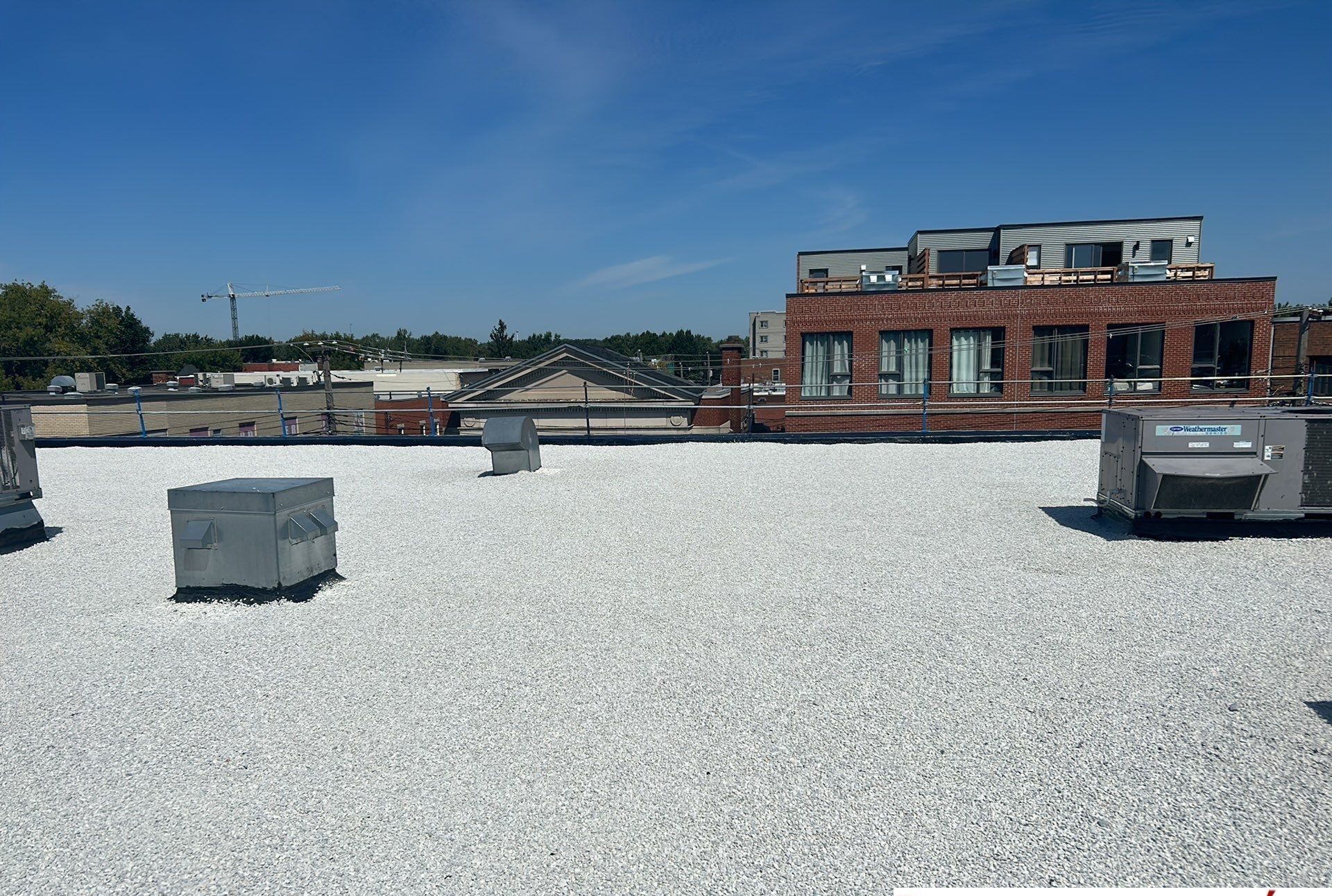 Un toit de gravier blanc avec un bâtiment en briques en arrière-plan