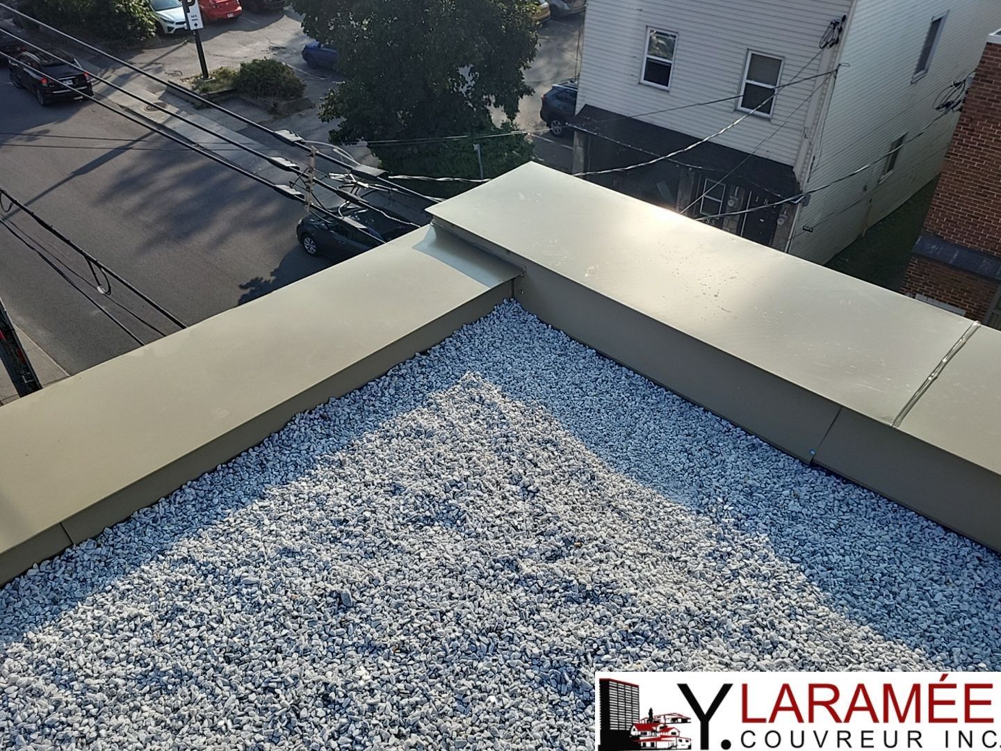 Une vue aérienne d'un toit avec un logo pour lylaramee covering inc.