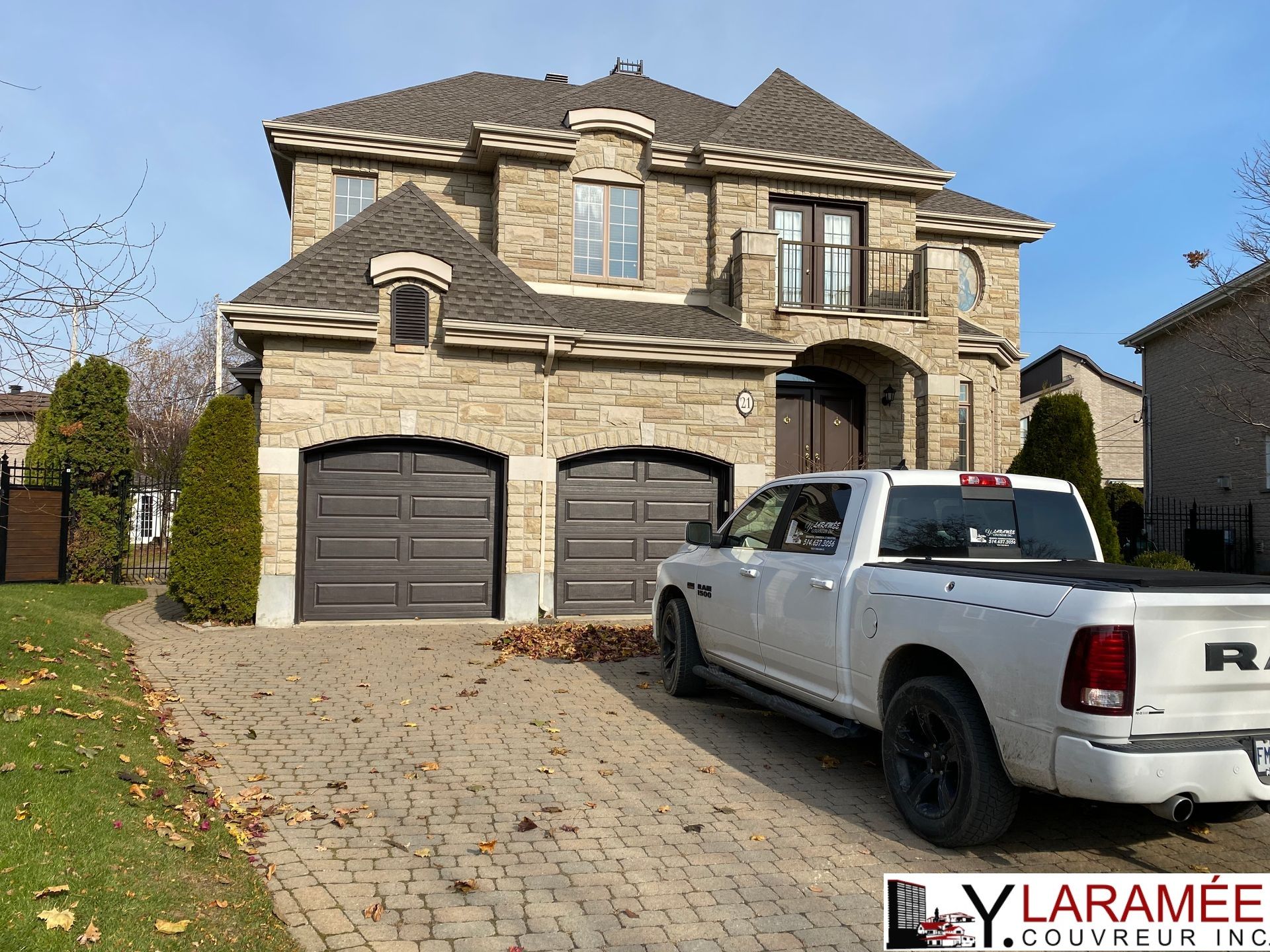 Un camion blanc est garé devant une grande maison.
